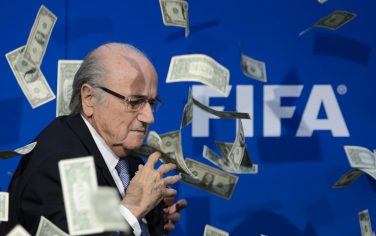 FIFA president Sepp Blatter looks on with fake dollars note flying around him thrown by a protester during a press conference at the football's world body headquarter's on July 20, 2015 in Zurich. FIFA said Monday that a special election will be held on February 26 to replace president Sepp Blatter.   AFP PHOTO / FABRICE COFFRINI        (Photo credit should read FABRICE COFFRINI/AFP/Getty Images)
