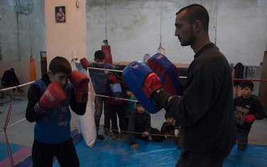Syrian former national boxing champion, Shaaban Kattan (R) leads a training session at the Shahba boxing club that he founded in Syria's war-torn Aleppo city on February 10, 2016 in a rebel held district of the city.Along with colleague Ahmad Mashallah, Kattan opened the club in the summer of 2015 to bring boxing back to a conflict-ravaged city. Bathed in the fluorescent light of a sparse basement in Aleppo, young boys pummel red punching bags under the close supervision of a former national boxing champion / AFP / KARAM AL-MASRI        (Photo credit should read KARAM AL-MASRI/AFP/Getty Images)