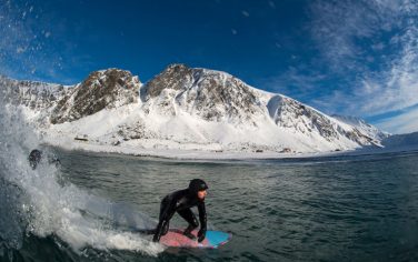 A surfer rides a wave at the snowy beach of Unstad, in Lofoten Island, Arctic Circle, on March 09, 2016.  
Surfers from all over the world comes to Lofoten island to surf in extrem conditions. Ocean temperature is 6-7 °C, air temperature around 0°C in spite of a weather very unstable.  / AFP / OLIVIER MORIN        (Photo credit should read OLIVIER MORIN/AFP/Getty Images)