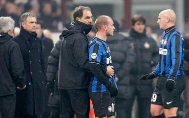 Inter Milan Dutch midfielder Wesley Sneijder, center, is persuaded to leave the field after receiving the red card during an Italian Serie A soccer match between Inter Milan and AC Milan at the San Siro stadium in Milan, Italy, Sunday, Jan. 24, 2010. At right is Inter Milan Argentine midfielder Esteban Cambiasso, and at left is Inter Milan coach Jose Mourinho, of Portugal. (AP Photo/Alberto Pellaschiar)