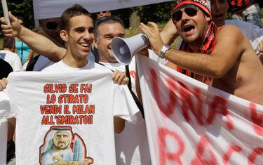 AC Milan supporters show banners outside the team's Milanello sporting center headquarter on the occasion of the first team training of the season, in Carnago, Northern Italy, Tuesday, July 20, 2010 . (AP Photo/Luca Bruno)