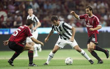 Montenegrin forward of Fc Juventus, Mirk Vucinic, pressed by italian defender of Ac Milan, Daniele Bonera (L) e french midfielder, Mathieu Flamini (R), during their friendly soccer match for 'Luigi Berlusconi Trophy' at Giuseppe Meazza Stadium in Milan, Italy, 21 August 2011. ANSA/MATTEO BAZZI 
