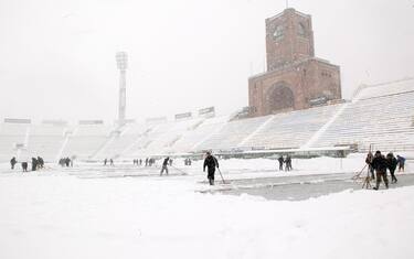 Spalatori tentano di ripulire il campo dello stadio Dall'Ara di Bologna oggi 2 gennaio La partita Bologna-Fiorentina che doveva giocarsi stasera e' stata rinviata per neve2012 .ANSA/MICHELE NUCCI