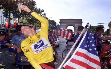 Paris, FRANCE:  (FILES) - Picture shows the winner of the 1999 Tour de France American Lance Armstrong raising a cup of champagne with his national flag during his honour lap on the Champs Elysees in Paris, 25 July 1999. Seven-time Tour de France champion Lance Armstrong was proven to have taken an endurance-boosting hormone during his first Tour de France triumph in 1999, the French sporting daily L'Equipe said 23 August 2005.  AFP PHOTO JOEL SAGET  (Photo credit should read JOEL SAGET/AFP/Getty Images)