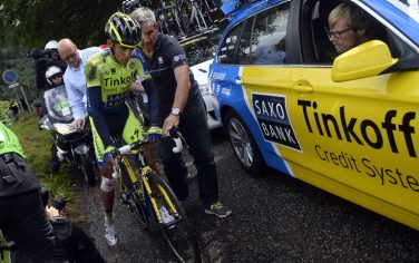 Russia's Tinkoff-Saxo cycling team manager Bjarne Riis (L) helps Spain's Alberto Contador after a fall during the 161.50 km tenth stage of the 101st edition of the Tour de France cycling race on July 14, 2014 between Mulhouse and La Planche des Belles Filles ski resort, eastern France.  AFP PHOTO / LIONEL BONAVENTURE        (Photo credit should read LIONEL BONAVENTURE/AFP/Getty Images)