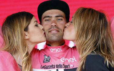 Two hostesses kiss Dutch cyclist Tom Dumoulin of Giant - Alpecin team as he bears the leader's pink jersey on the podium in the 7th stage of 99th Giro d'Italia, Tour of Italy, from Sulmona to Foligno of 211 km on May 13, 2016 in Foligno, Italy. / AFP / LUK BENIES        (Photo credit should read LUK BENIES/AFP/Getty Images)