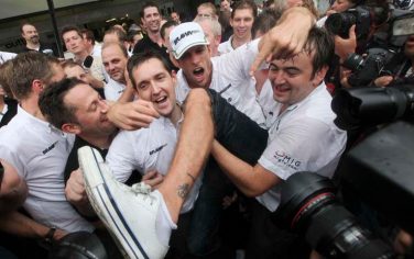 Brawn GP's driver Jenson Button, of Britain, with a cap, celebrates with teammates in the pit after winning the 2009 F1 World Championship by arriving fifth during  Brazil's F1 Grand Prix at the Interlagos race track in Sao Paulo, Sunday, Oct. 18, 2009. (AP Photo/Andre Penner)
