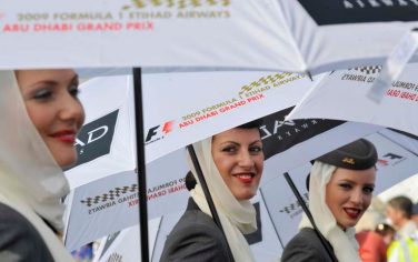 Flight attendants working as grid girls hold umbrellas at the Yas Marina racetrack in Abu Dhabi, United Arab Emirates, Thursday, Oct. 29, 2009. The Emirate Formula One Grand Prix will take place here on Sunday, Nov. 1, 2009. (AP Photo/Gero Breloer)
