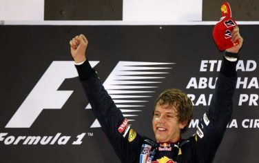 epa01917506 German Formula One driver Sebastian Vettel of Red Bull celebrates his victory on the podium at the newly built racetrack Yas Marina Circuit in Abu Dhabi, United Arab Emirates, 01 November 2009.  EPA/JENS BUETTNER