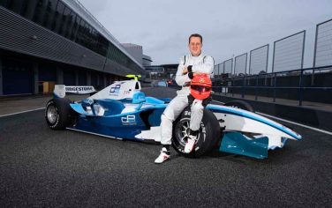 In this image released by GP2 Media, Formula 1 driver Michael Schumacher of Germany poses for a picture before with a GP2 car at the racetrack in Jerez de la Frontera, southern Spain, on Tuesday, Jan. 12, 2010. Schumacher has started his preparations for his Formula 1 return by getting behind the wheel of a GP2 car to begin a three-day testing session. (AP Photo/Malcolm Griffiths, GP2 Media) **EDITORIAL USE ONLY, NO SALES**