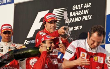Ferrari driver Fernando Alonso of Spain, above, pours rose water over the head of Ferrari team principal Stefano Domenicali of Italy, right, as McLaren Mercedes driver Lewis Hamilton of Britain, left, and Ferrari driver Felipe Massa of Brazil, below center, look on during the presentation ceremony on the podium after he won the Bahrain Formula One Grand Prix at the Bahrain International Circuit in Sakhir, Bahrain Sunday, March 14, 2010. (AP Photo/Ben Curtis)