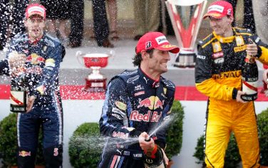 Red Bull driver Mark Webber of Australia celebrates sprying champagne after winning the Monaco Formula One Grand Prix at the Monaco racetrack, in Monaco, Sunday, May 16, 2010. In background are seen second place Red Bull driver Sebastian Vettel of Germany, left, and third place Renault driver Robert Kubica of Poland. (AP Photo/Luca Bruno)