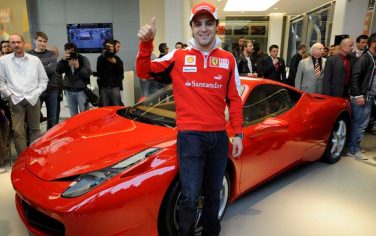 Ferrari Formula One driver Felipe Massa, front, poses for photographers after he opened the new Ferrari Scuderia showroom in Prague, Czech Republic, on Wednesday, May 5, 2010. He also introduced the model 458 Italia road edition, behind. (AP Photo/CTK, Michal Krumphanzl) **SLOVAKIA OUT**
