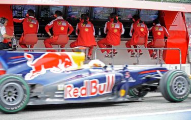 The Ferrari Formula One team monitors the second free practise session while german Sebastian Vettel from Red Bull passes in his car at the race track in Hockenheim, Germany, Friday, July 23, 2010. The German Formula One Grand Prix will take place on Sunday July 25. (AP Photo/Martin Meissner)