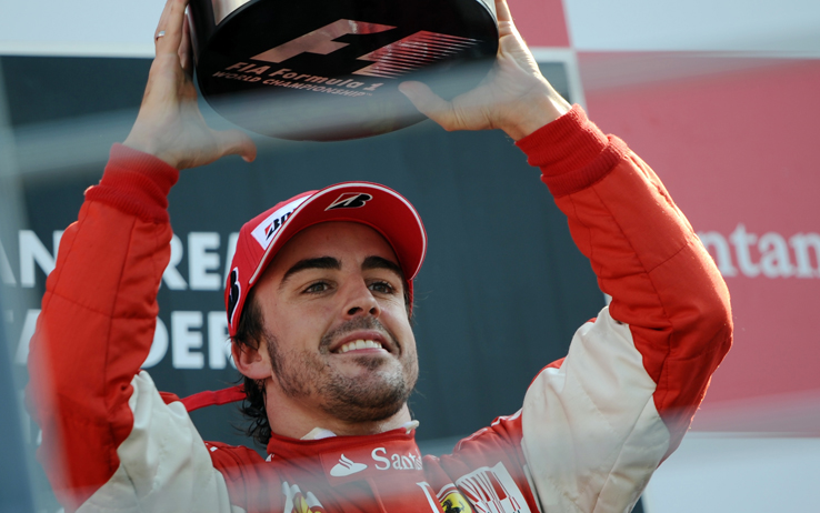 Ferrari's Spanish driver Fernando Alonso celebrates on the podium of the Autodromo Nazionale circuit on September 12, 2010 in Monza, after the Formula One Italian Grand Prix. Ferrari's Spanish driver Fernando Alonso won the race ahead of McLaren Mercedes' British driver Jenson Button and Ferrari's Brazilian driver Felipe Massa. AFP PHOTO / FRED DUFOUR (Photo credit should read FRED DUFOUR/AFP/Getty Images)