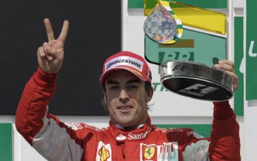 Spanish Ferrari driver Fernando Alonso holds up his third place trophy during a podium ceremony of the Brazilian Grand Prix at Interlagos circuit in Sao Paulo, on November 7, 2010. Sebastian Vettel led a Red Bull one-two at the Brazilian Grand Prix on Sunday finishing ahead of team-mate Mark Webber. World Championship leader Fernando Alonso in a Ferrari was third and he will start next week's final race in Abu Dhabi eight points ahead of Webber and 15 points ahead of Vettel. The result saw Red Bull crowned constructors champions for the first time.  AFP PHOTO/Mauricio LIMA (Photo credit should read MAURICIO LIMA/AFP/Getty Images)