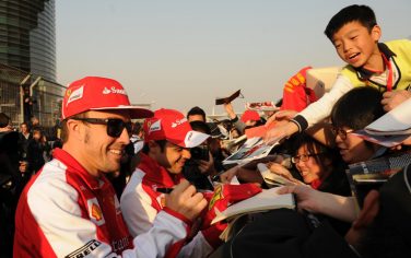 Ferrari driver Fernando Alonso of Spain (L) and team mate Felipe Massa of Brazil  (C) sign autographs for Chinese fans at the Shanghai Circuit ahead of the Formula One Chinese Grand Prix in Shanghai on April 11, 2013. The Formula One Chinese Grand Prix will take place on April 14. AFP PHOTO/Peter PARKS        (Photo credit should read PETER PARKS/AFP/Getty Images)