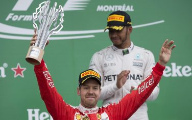 epa05360366 German Formula One driver Sebastian Vettel of Scuderia Ferrari (front) celebrates on the podium after finishing in second place in the 2016 Formula One Grand Prix of Canada at the Gilles Villeneuve circuit in Montreal, Canada, 12 June 2016, as winner British Formula One driver Lewis Hamilton of Mercedes AMG GP (back) looks on.  EPA/VALDRIN XHEMAJ