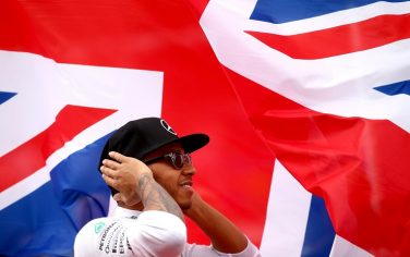 NORTHAMPTON, ENGLAND - JULY 05:  Lewis Hamilton of Great Britain and Mercedes GP stands for the national anthem before the Formula One Grand Prix of Great Britain at Silverstone Circuit on July 5, 2015 in Northampton, England.  (Photo by Clive Rose/Getty Images)