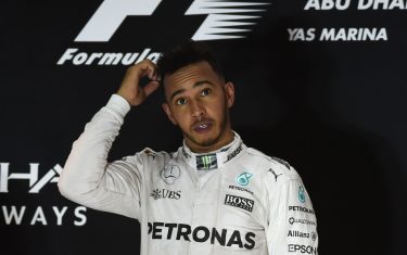 Mercedes AMG Petronas F1 Team's British driver Lewis Hamilton stands on the podium after winning the Abu Dhabi Formula One Grand Prix at the Yas Marina circuit on November 27, 2016. / AFP / MOHAMMED AL-SHAIKH        (Photo credit should read MOHAMMED AL-SHAIKH/AFP/Getty Images)
