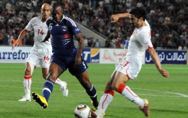 France's William Gallas, center, vies with Tunisia's Fahid Ben Khalfallah, right, as Mehdi Nafti, left, looks on during a pre-World Cup friendly match in preparation for the 2010 World Cup taking place in South Africa, at November 7 Stadium in Rades, on the outskirts of Tunis, Sunday, May 30, 2010.  (AP Photo/Hassene Dridi)