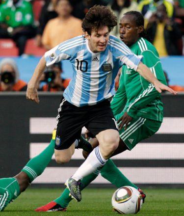 Nigeria's Lukman Haruna, left, falls as Argentina's Lionel Messi, second from right, is tackled by Nigeria's Chidi Odiah, right, during the World Cup group B soccer match between Argentina and Nigeria at Ellis Park Stadium in Johannesburg, South Africa, on Saturday, June 12, 2010.  (AP Photo/Luca Bruno)