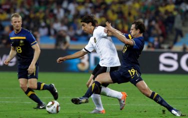 Germany's Sami Khedira, left, is challenged by Australia's Richard Garcia , right, during the World Cup group D soccer match between Germany and Australia at the stadium in Durban, South Africa, Sunday, June 13, 2010.  (AP Photo/Schalk van Zuydam)