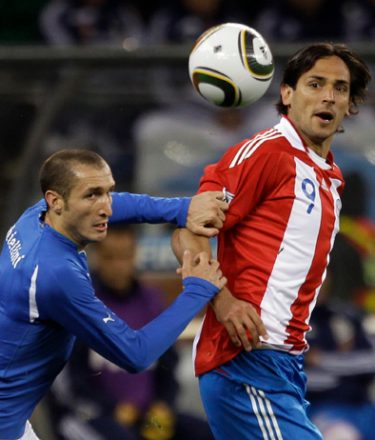Italy's Giorgio Chiellini, left, vies for the ball with Paraguay's Roque Santa Cruz during the World Cup group F soccer match between Italy and Paraguay in Cape Town, South Africa, Monday, June 14, 2010.  (AP Photo/Julie Jacobson)