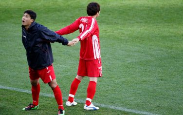 North Korea's Cha Jong Hyok, left, stretches with an unidentified teammate during a training session at the Green Point stadium in Cape Town, South Africa, Sunday, June 20 2010. North Korea will play Portugal Monday in a soccer World Cup group G match. (AP Photo/Armando Franca)