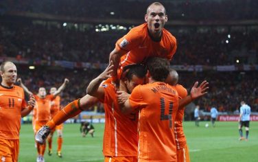 epa02239017 Dutch Wesley Sneijder (top) and teammates celebrate Giovanni van Bronckhorst (C no. 5) after he scored the 1-0 lead during the FIFA World Cup 2010 semi final match between Uruguay and Netherlands at the Green Point stadium in Cape Town, South Africa, 06 July 2010.  EPA/OLIVER WEIKEN Please refer to www.epa.eu/downloads/FIFA-WorldCup2010-Terms-and-Conditions.pdf