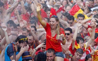 Spanish fans are sprayed with water before the start of the live broadcast at the Recoletos' boulevard in Madrid of the World Cup soccer final between Spain and the Netherlands, which is being played in South Africa, on Sunday, July 11, 2010. (AP Photo/Paul White)