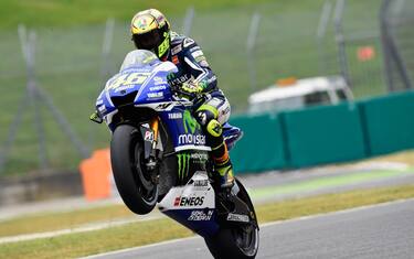 SCARPERIA, ITALY - MAY 30:   Valentino Rossi of Italy and Movistar Yamaha MotoGP  lifts the front wheel during MotoGp of Italy - Free Practice at Mugello Circuit on May 30, 2014 in Scarperia, Italy.  (Photo by Mirco Lazzari gp/Getty Images)
