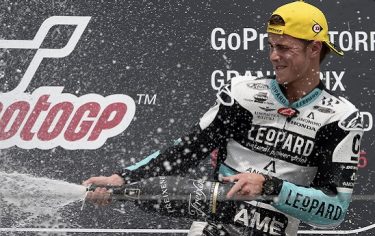 Honda's British rider Danny Kent sprays with champagne on the podium as he celebrates winning the Moto3 Grand Prix of Germany at the Sachsenring Circuit on July 12, 2015 in Hohenstein-Ernstthal, eastern Germany. AFP PHOTO / ROBERT MICHAEL        (Photo credit should read ROBERT MICHAEL/AFP/Getty Images)