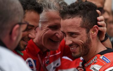 Ducati Team's Italian rider Andrea Dovizioso (R) is congratulated by team members after taking pole position in the qualifying session of Malaysian MotoGP at the Sepang International circuit on October 29, 2016. / AFP / MOHD RASFAN        (Photo credit should read MOHD RASFAN/AFP/Getty Images)