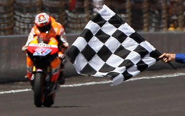 INDIANAPOLIS, IN - AUGUST 28:  Casey Stoner #27 of Australia corsses the finish line to win the Red Bull Indianapolis GP at Indianapolis Motorspeedway on August 28, 2011 in Indianapolis, Indiana.  (Photo by Jamie Squire/Getty Images)