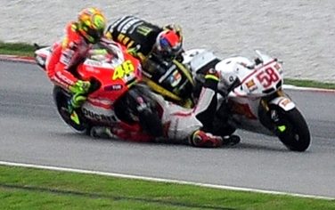 Ducati rider Valentino Rossi (L) of Italy, Yamaha rider Colin Edwards (top) of the US, and Honda rider Marco Simoncelli (C) of Italy collide at turn 11 of the Sepang racing circuit during the Malaysian MotoGP on October 23, 2011. Celebrated Italian rider Marco Simoncelli died after the crash that resulted in the cancellation of the race, in the latest tragedy to hit motor sports.  The smash occurred just minutes after the race began when the 24-year-old Honda rider's bike veered across the track and into the path of riders Colin Edwards and Valentino Rossi.       MALAYSIA OUT       AFP PHOTO / RUBEN YAP (Photo credit should read Ruben Yap/AFP/Getty Images)