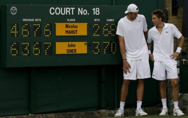 epa02220263 John Isner (L) of the USA poses with Nicolas Mahut (R) of France next to the scoring board after winning his first round match for the Wimbledon Championships at the All England Lawn Tennis Club, in London, Britain, 24 June 2010.  EPA/GLYN KIRK / POOL  Reuters