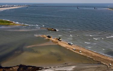 Louisiana National Guard use dump trucks to dam off part of the marsh on Elmer's Island in Grand Isle, La., Monday, May 10, 2010. Oil giant BP PLC's oil rig exploded April 20, in the Gulf of Mexico killing 11 workers. It sank two days later, and oil is still pouring into the gulf.  (AP Photo/Alex Brandon)
