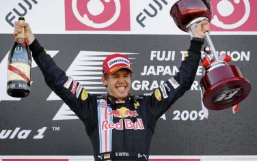 epa01885757 German Formula One driver Sebastian Vettel jubilates on the podium after he won the Formula One Grand Prix of Japan at the Suzuka Circuit in Suzuka, Japan, 04 October 2009.  EPA/FRANCK ROBICHON