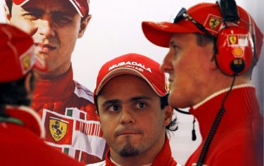 epa01679312 Brazilian Formula One driver Felipe Massa (C) of Ferrari listens to Former World Champion Michael Schumacher (R) at the end of the last practice session at the Albert Park Circuit in Melbourne on the first leg of the 2009 Formula 1 Grand Prix, Australia, 28 March 2009. Australian Formula One Grand Prix will take place on 29 March.  EPA/DIEGO AZUBEL